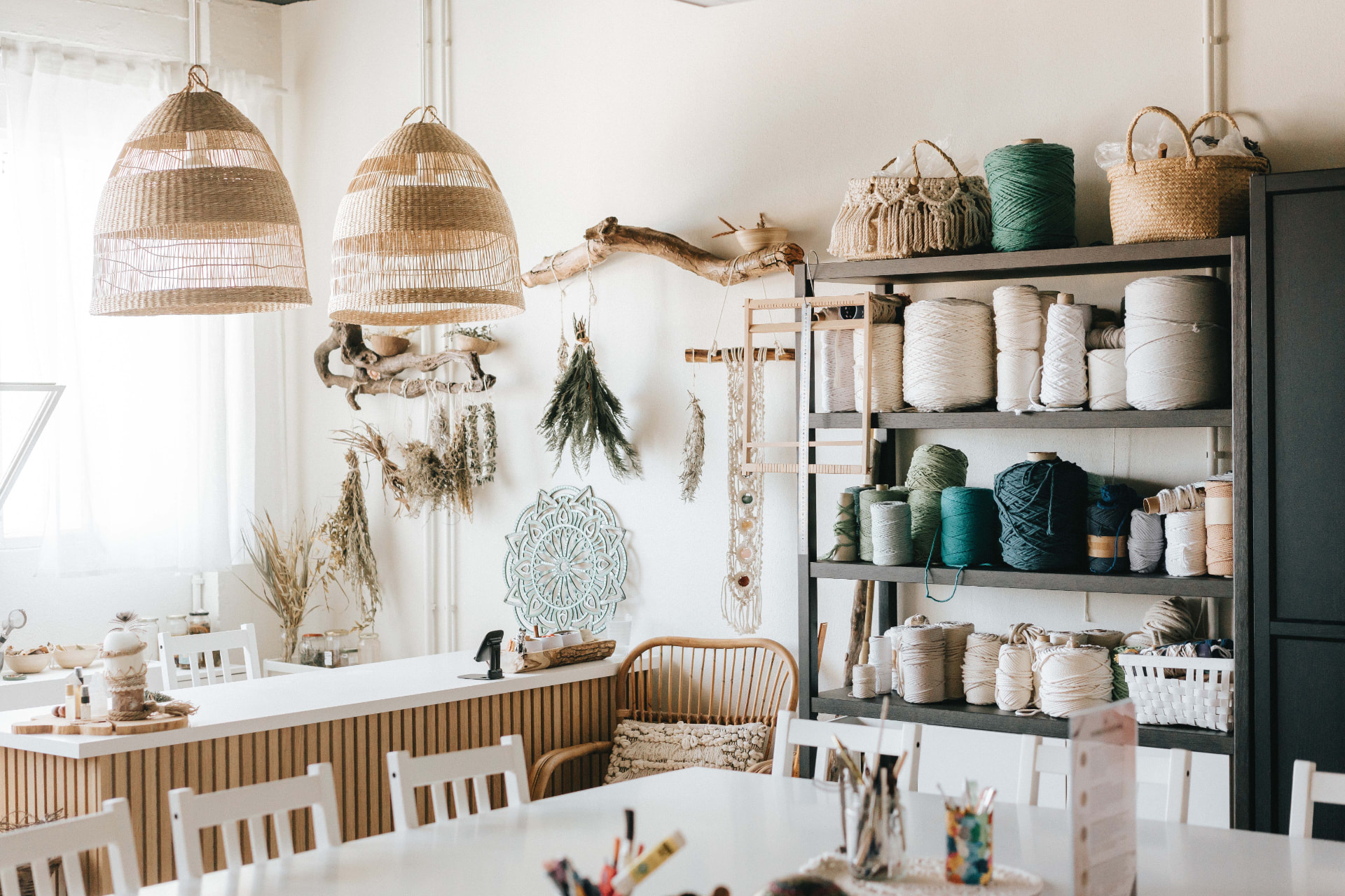 Atelier criativo TEULU em Lisboa, com mesas de trabalho, candeeiros em fibra natural e estantes de fios para macramé